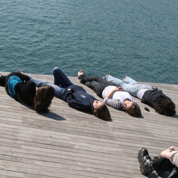 four women relaxing on a pier