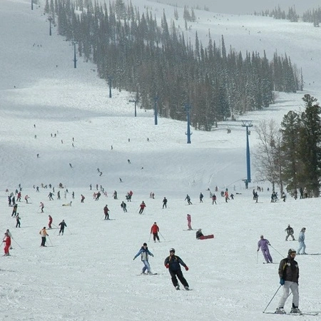 A skiing slope full of people skiing