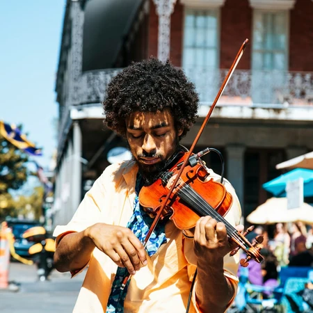 a street musician playing the violin next to a building