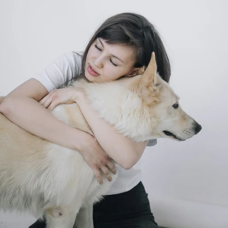 a young girl hugging her dog affectionately